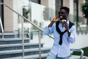 High fashion look.Young stylish confident businessman model in casual clothes walking in the street in sunglasses.