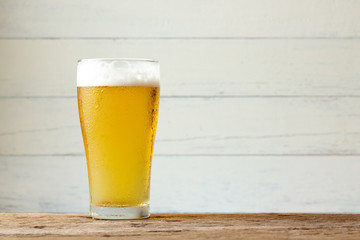 Glass beer on wood background with copy space.