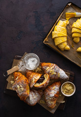 Wall Mural - Fresh croissants with chocolate on a dark stone background with copy space top view