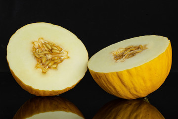 Group of two halves of fresh yellow melon canary isolated on black glass