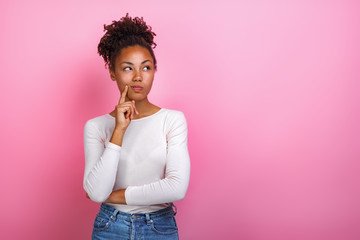 studio portrait of a thinking pose girl touching herself face by index finger- image