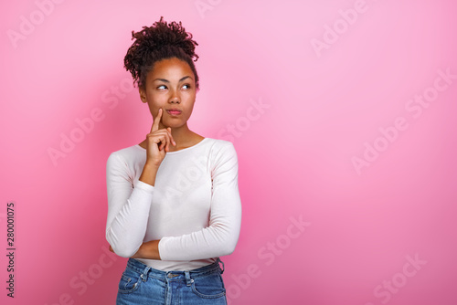 Fotomural Studio portrait of a thinking pose girl touching herself face by index finger- I