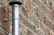 stainless chimney in stone wall