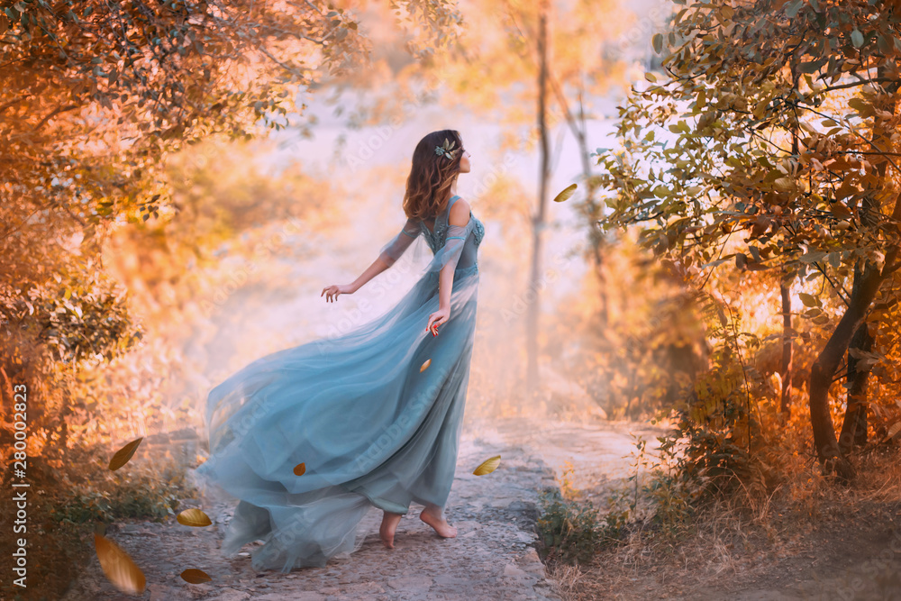 delightful light girl in sky blue turquoise dress with long flying train, princess of wind and daughter of storm, lady with dark hair throws fallen leaves to ground, autumn story in art processing. - obrazy, fototapety, plakaty 