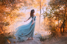 Delightful Light Girl In Sky Blue Turquoise Dress With Long Flying Train, Princess Of Wind And Daughter Of Storm, Lady With Dark Hair Throws Fallen Leaves To Ground, Autumn Story In Art Processing.