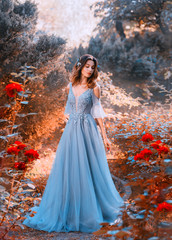 sad princess walks in fading autumn garden with withered plants, lady with short dark hair in chic l