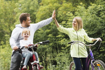 Wall Mural - Family on bicycles giving high five