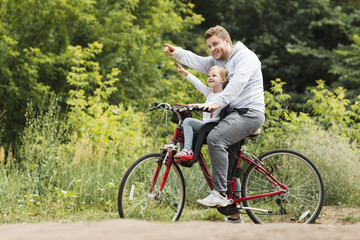 Wall Mural - Sideways father and daughter on bicycle