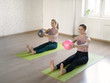 © junky_jess - Two caucasian girls practise pilates with small fit balls, in fitness studio, loft style, selective focus.