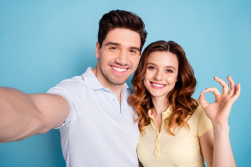 Canvas Print - Close up photo of foxy lady brunet guy pair making selfies fingers okey symbol wear casual t-shirts isolated blue background