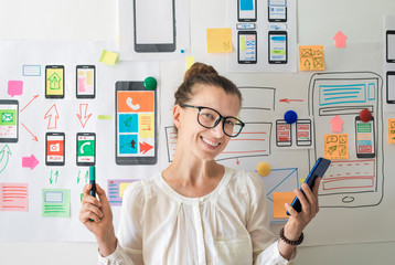 Wall Mural - mobile app designer. woman specialist in the development of programs for smartphones.