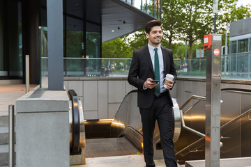 Sticker - Attractive young businessman wearing suit walking