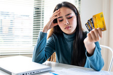 Unhappy Girl Holding Three Credit Cards, Feeling Stressed About Tax And Debt Problem From Shopping Online.
