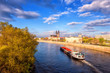 View of Magdeburg with cathedral, river Elbe and cargo boat, beautiful bright morning cityscape with blue sky and clouds, Saxony, Germany. Outdoor travel background