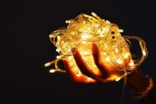 Hand Holding LED String Light That Are Used To Decorate The Festival
