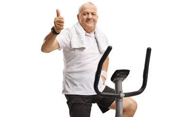 Poster - Mature man on an exercise bike showing thumbs up