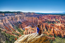 Girl Sitting On The Top Of The Mountain Looking At Beautiful View. Woman Relaxing On The Rock On Summer Vacation Hiking Trip. Inspiration Point. Bryce Canyon National Park,Utah, USA