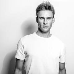 Elegant young handsome man in classic shirt. Black-white portrait.