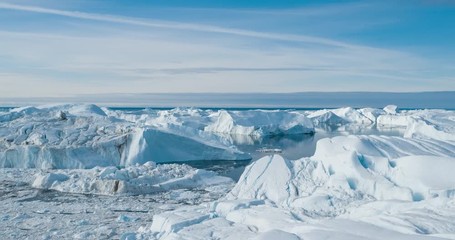 Wall Mural - Drone video of Iceberg and ice from glacier in arctic nature landscape on Greenland. Aerial video drone photo of icebergs in Ilulissat icefjord. Affected by climate change and global warming.