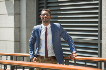 handsome young adult african man in suit and glasses