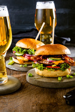 Gourmet Hamburgers, French Fries And Glasses Of Beer On Table  