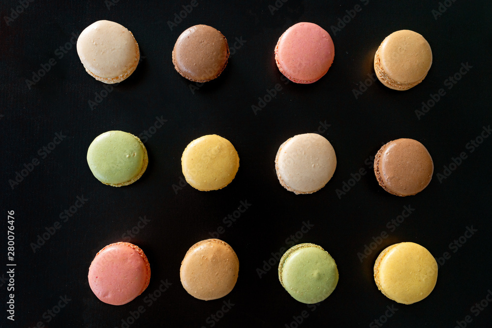 Macarons top view on black background. Baking sheet fresh out of the ...
