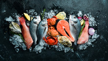 Seafood: Dorado, Salmon, Crab, Grouper, Oysters. On A Black Stone Background. Top View. Free Space For Your Text.