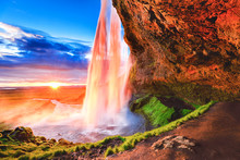 Seljalandsfoss waterfall in Iceland, Europe. Picturesque landscape photography in golden hour, day to night time, sun flare opposite of incredible Icelandic waterfall Seljalandsfoss - iconic landmark.