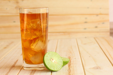 ice tea with slice of lemon in glass on the wooden background