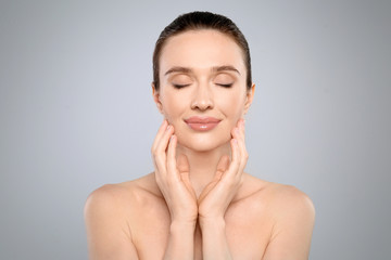 Poster - Portrait of beautiful young woman with perfect skin on grey background. Spa treatment