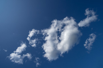 a white cloud against a blue sky in the midday sun