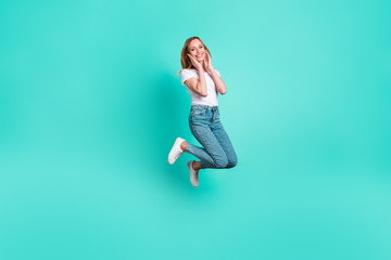 Wall Mural - Full length photo of cute youngster touching her face with palms isolated over teal turquoise background