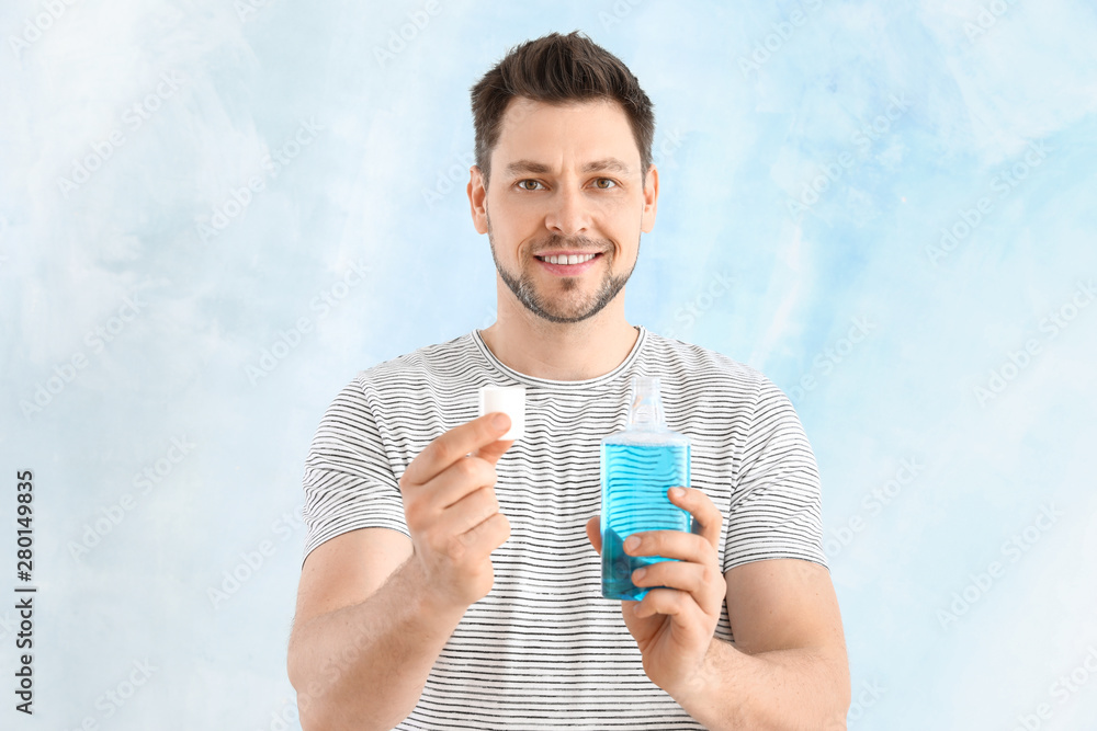 Man with mouth rinse on light background