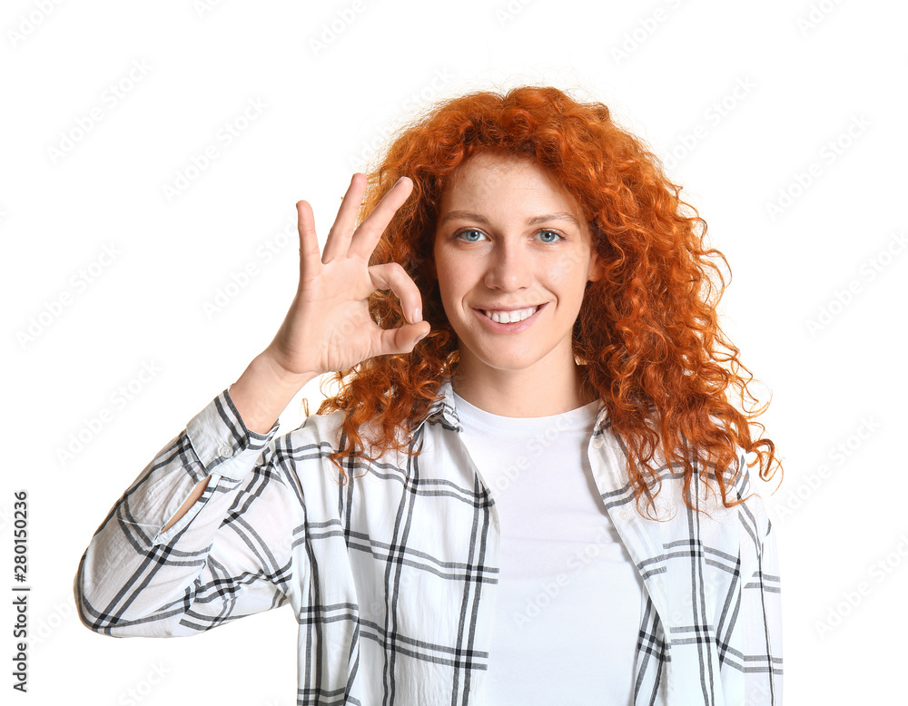 Beautiful redhead woman showing OK on white background