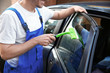 Male worker tinting car window outdoors