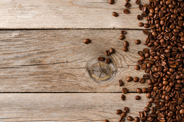 Wall Mural - Overhead shot of roasted coffee beans on wooden background.