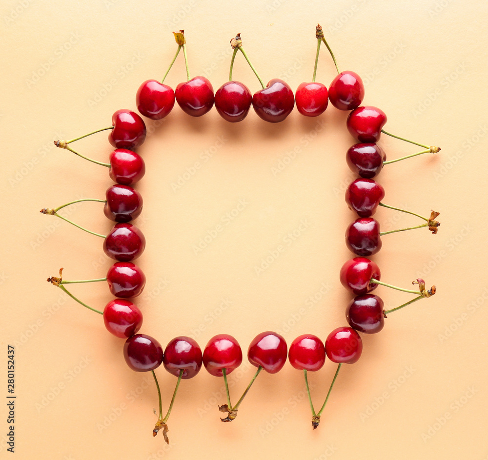 Frame made of sweet ripe cherry on color background