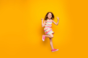 Wall Mural - Full size photo of cheerful kid jumping making v-signs isolated over yellow background