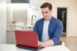 © studioprodakshn - young handsome man working in his laptop from home freelancing
