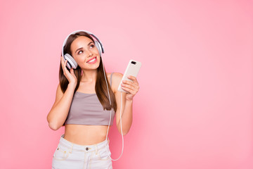 Sticker - Portrait of cute curious lady looking up holding device wearing white denim jeans gray tank-top isolated over pink background