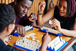 © AS Photo Family - Group of three african american friends play table games.