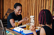 © AS Photo Family - Group of three african american friends play table games.
