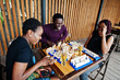 © AS Photo Family - Group of three african american friends play table games.