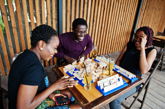 group of three african american friends play table games.