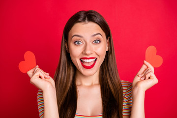 Wall Mural - Close-up photo of nice optimistic pleased cheerful with toothy beaming smile she her lady holding two little heart shaped figures in hands isolated bright background