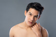 Portrait of shirtless young asian handsome man touching face