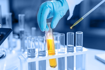 scientist with equipment and science experiments, laboratory glassware containing chemical liquid fo