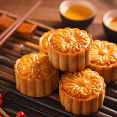 Moon cake Mooncake table setting - Round shaped Chinese traditional pastry with tea cups on wooden background, Mid-Autumn Festival concept, close up.