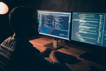 Close up back rear behind photo handsome he him his guy coder typing php css html keyboard development outsource IT processing language monitors table office wear specs formalwear plaid shirt