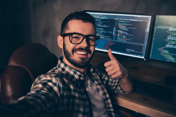 Close up photo handsome he him his guy coder make take selfies blog advising web agency thumb up development outsource IT processing language monitors table office wear specs formalwear plaid shirt